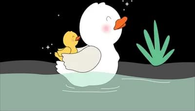 White duck and duckling standing on a pale green bank with reeds