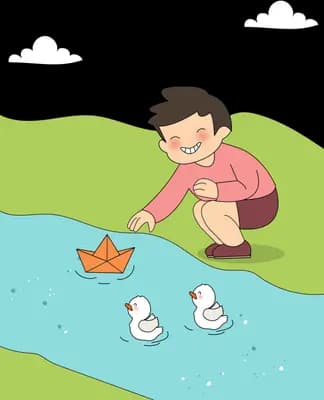 Boy crouching on a grassy bank floating a paper boat past two ducks
