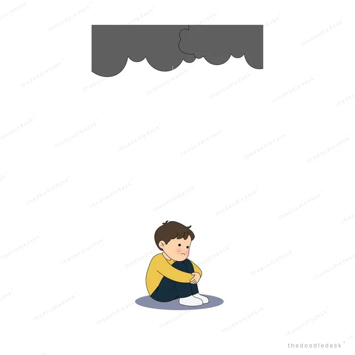 Boy hugging his knees under a heavy dark grey cloud
