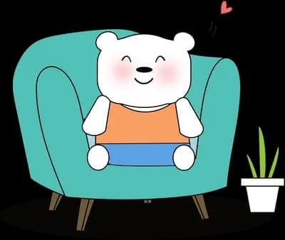 Bear working on a laptop on a teal sofa