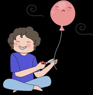 Boy sitting cross-legged clapping at a balloon