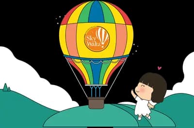 Boy watching a hot air balloon rise from hills