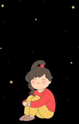 Girl in red sitting hugging her knees among floating specks of light