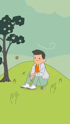 Boy sitting on a green hill under a leafy tree in spring
