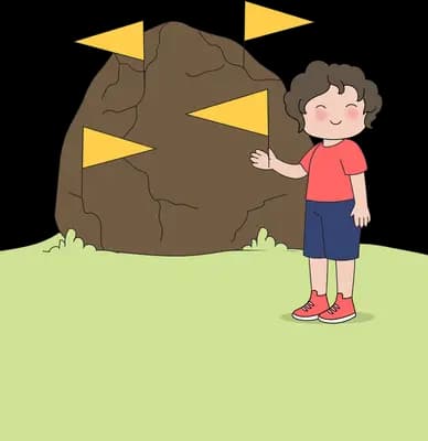 Boy pulling yellow wedges out of a big brown boulder on a green lawn