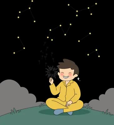 Boy in a yellow tracksuit sitting on grass holding a tiny object