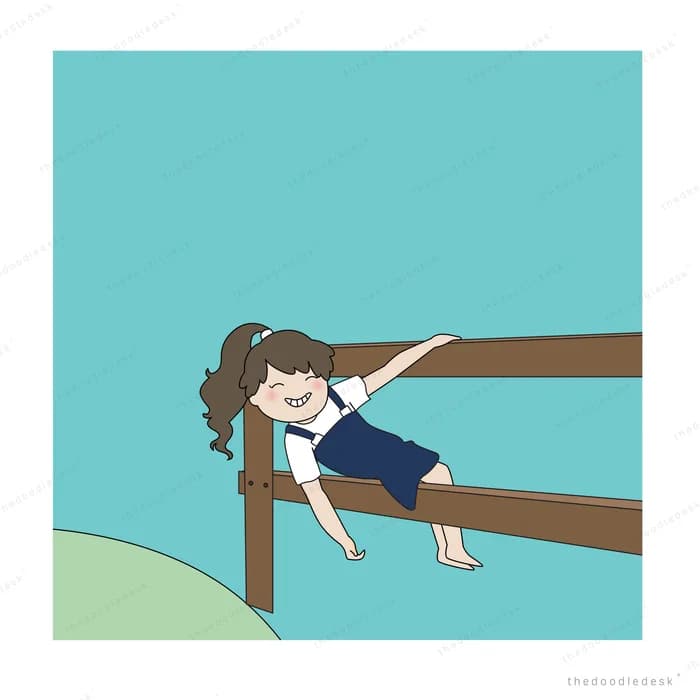 Girl balancing along a wooden rail over grass