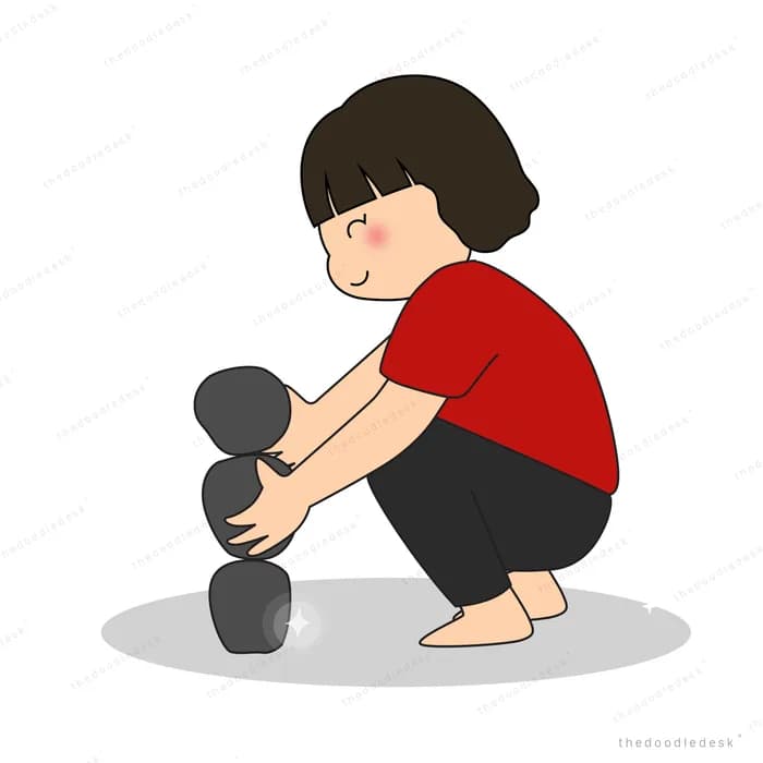 Girl crouching to balance a stack of dark stones