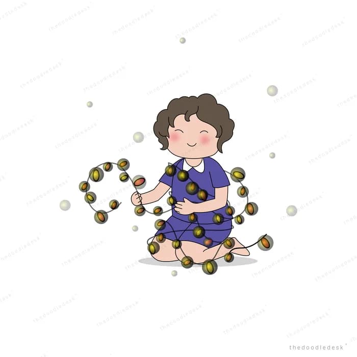 Girl sitting on the ground threading dark berries into a long garland