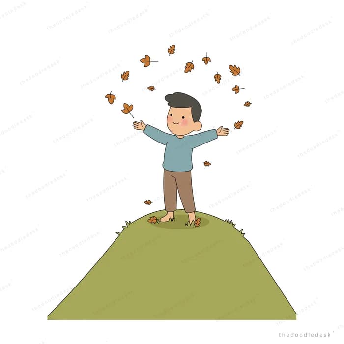 Boy standing on a green hilltop tossing autumn leaves into the air