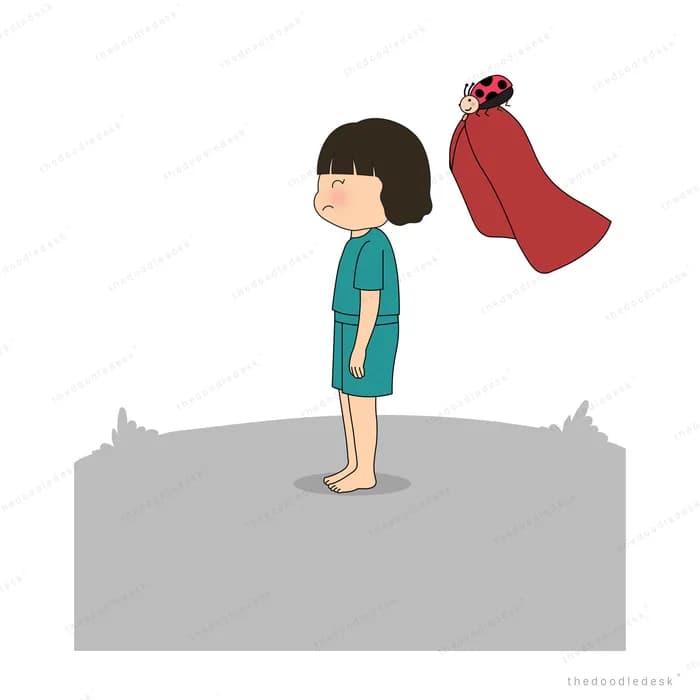 Woman standing on a bare grey mound as her red cape blows away behind her