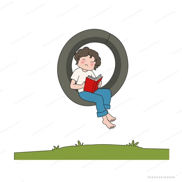 Boy sitting inside a tyre swing reading a red book